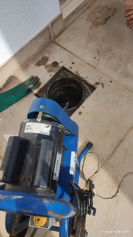 Máquina de desentupimento profissional sobre ralo durante serviço
